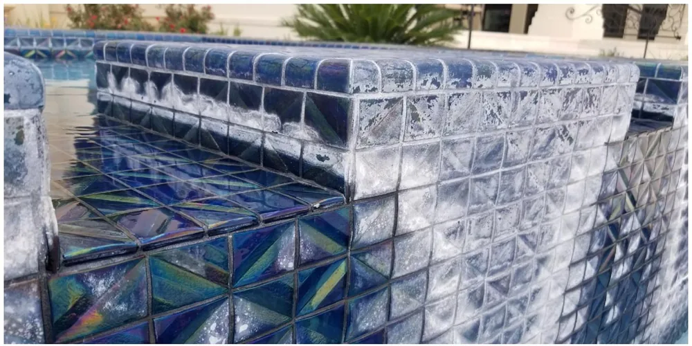 Before: heavy white calcium scale covering iridescent diamond-pattern tile
