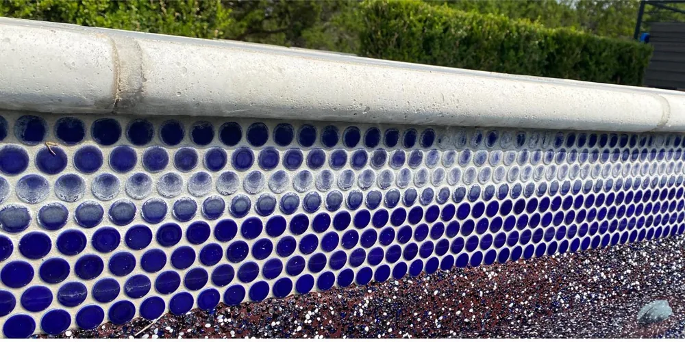 Before: hazy, calcium-streaked navy waterline tile