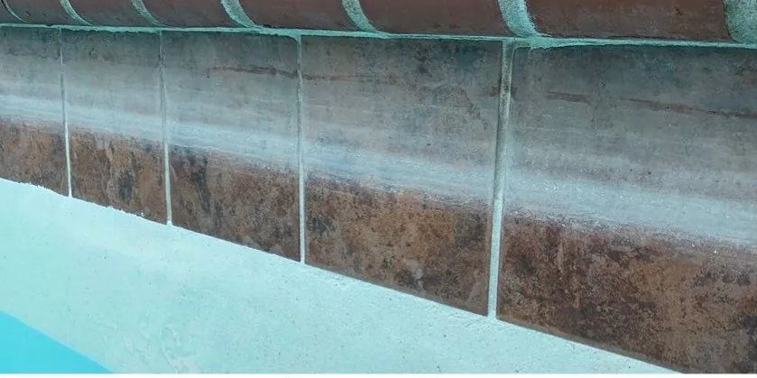 Before: hazy film across rust-toned stone-look tile