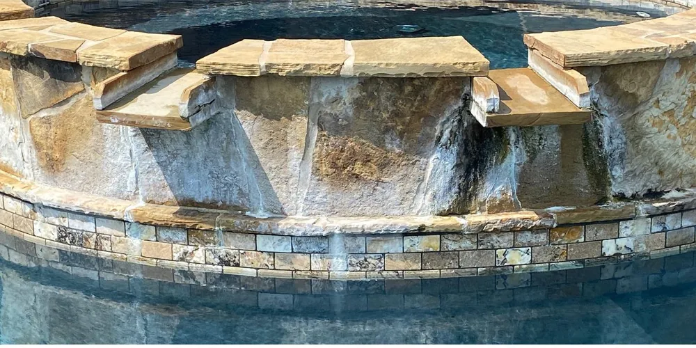 Before: weathered, mossy natural stone spa coping