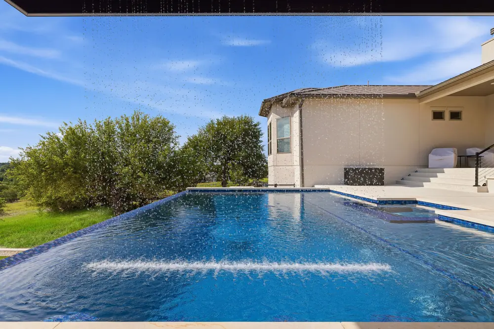 Rain-curtain water feature at a repaired backyard pool