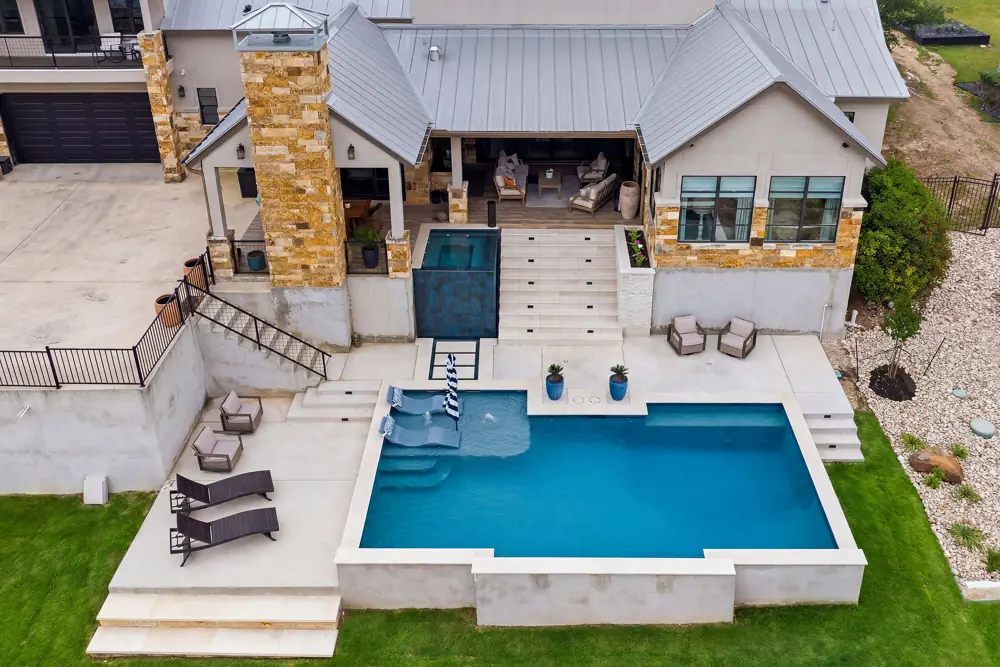 Aerial view of a modern pool with a glass spa wall at a Buda-area home
