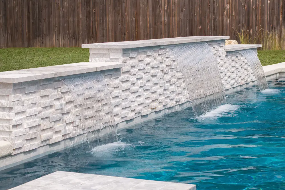 Multi-spillway stacked-stone waterfall wall added during a pool renovation