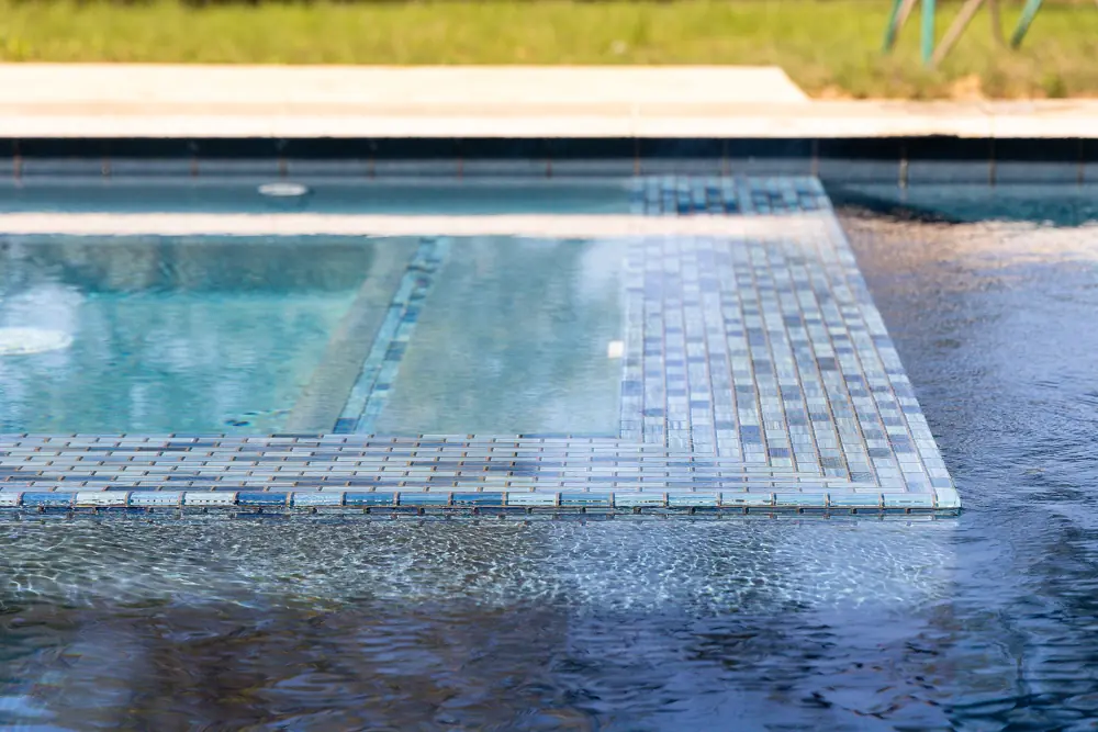 Close-up of a wet blue mosaic pool step