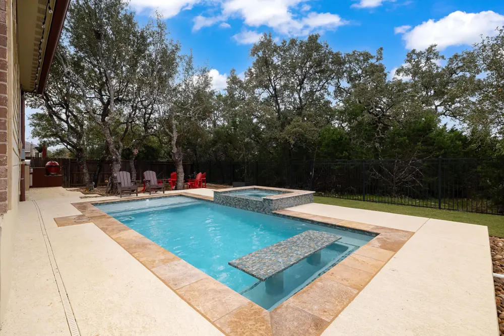 Renovated rectangular pool and spa under mature oak trees