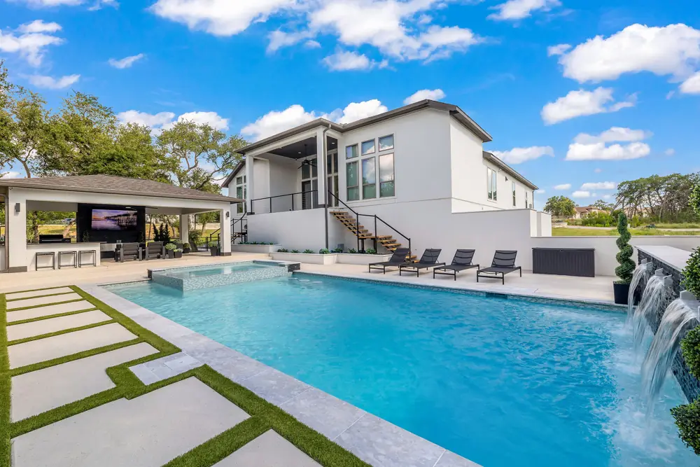 Resurfaced pool with a bright blue tile spillway and covered cabana
