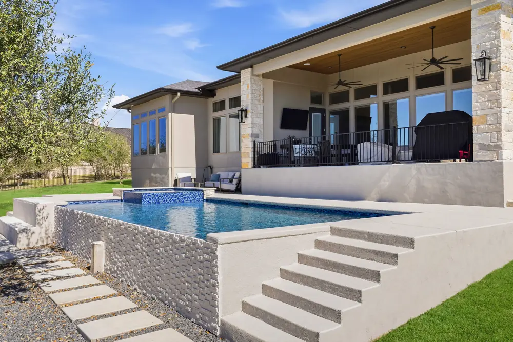 Infinity-edge pool with a repaired tile edge and Hill Country view