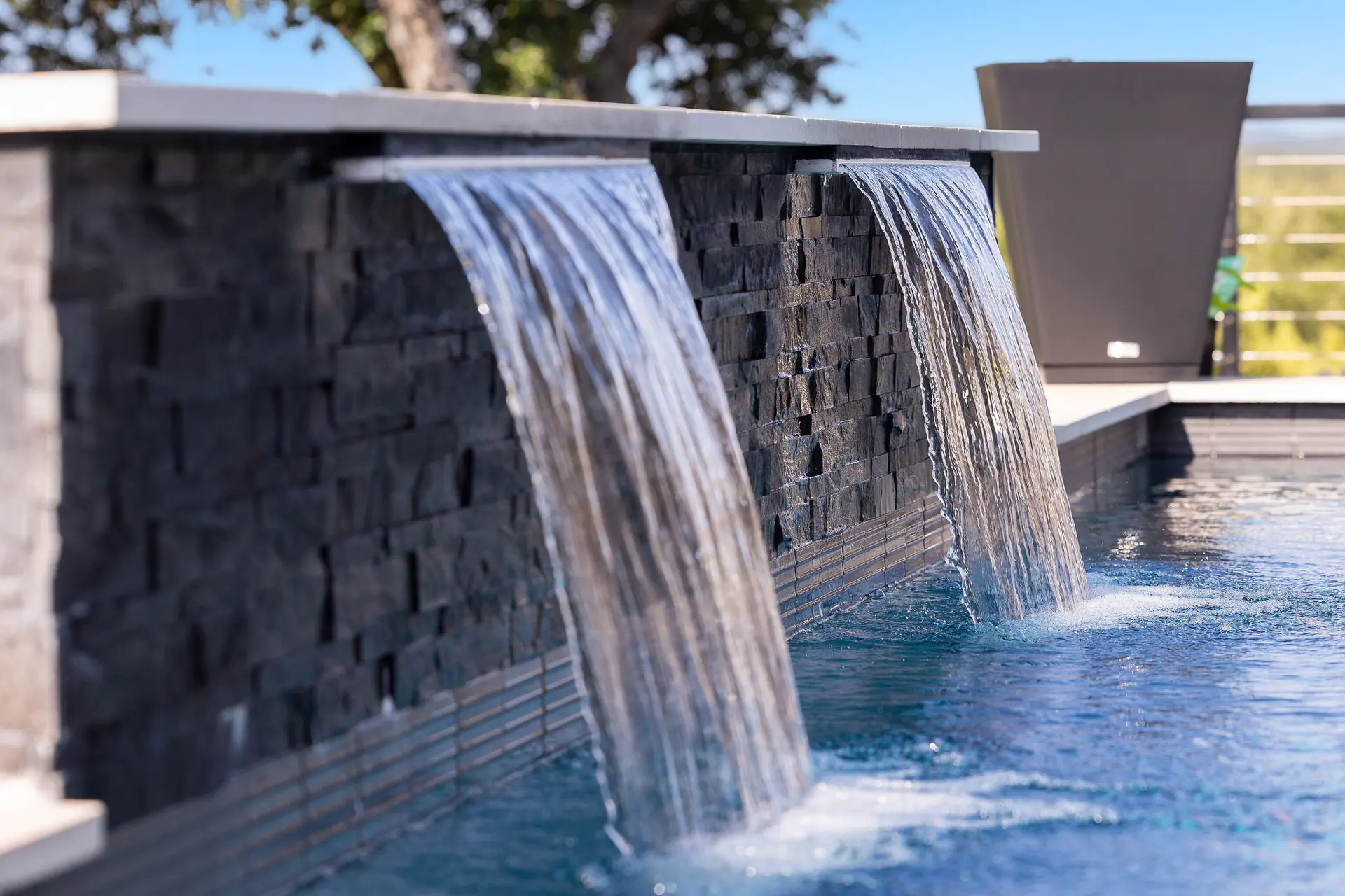 Dual waterfall spillway pool with a bright sky near Blanco