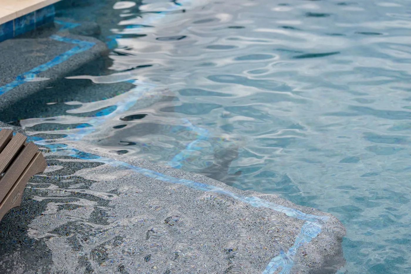 Freshly resurfaced pool with smooth, clear water and a clean tile waterline