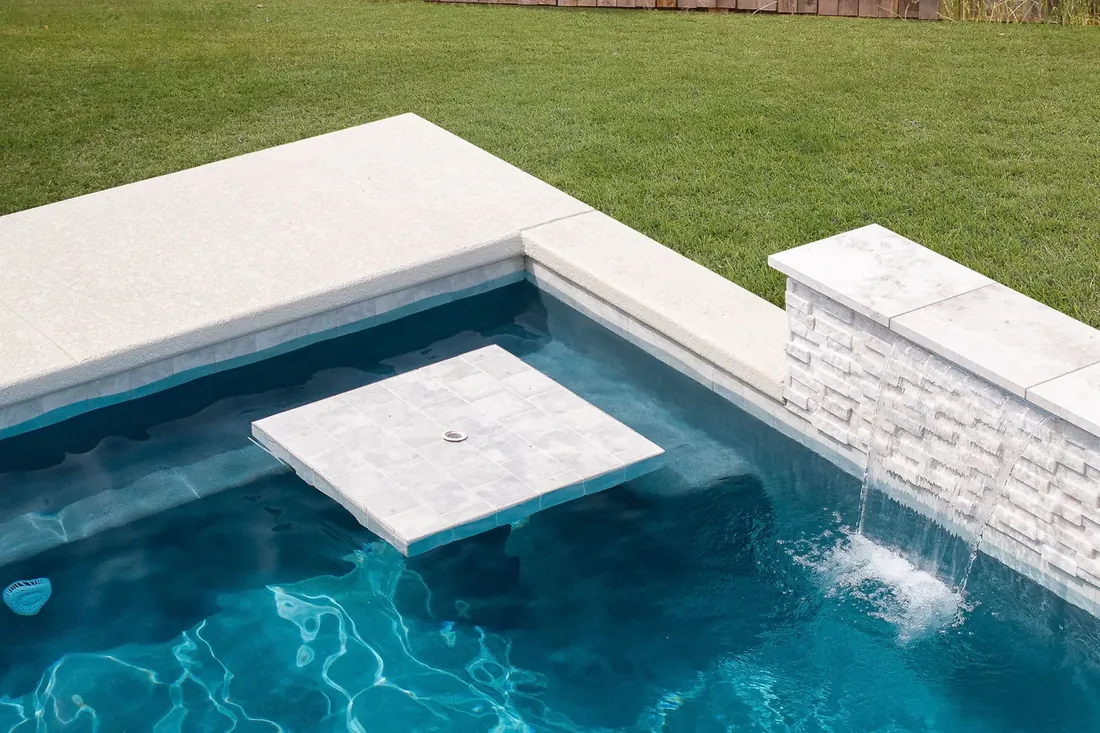 Waterfall spillway feature at a repaired backyard pool