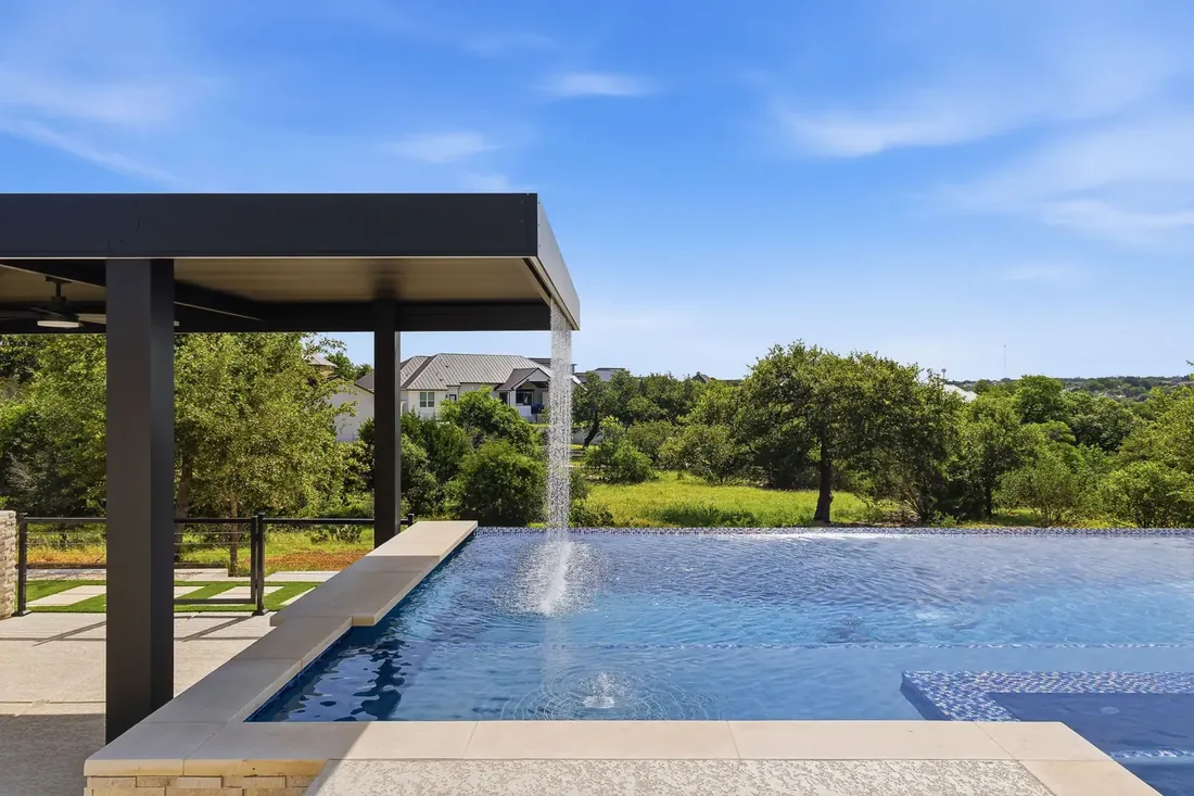 Well-maintained pool with covered patio at dusk
